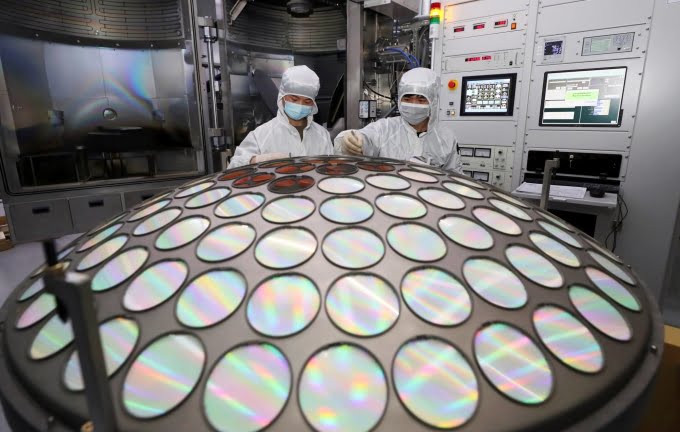 Employees work at the semiconductor chip production line of Jiangsu Azure (China). Photo: Reuters