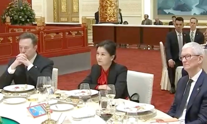 Ms. Chu Quanfei is seated between Elon Musk and Tim Cook. Photo: CCTV.